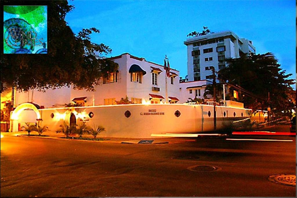 un bâtiment avec un mur blanc sur le côté d'une rue dans l'établissement At Wind Chimes Boutique Hotel, à San Juan