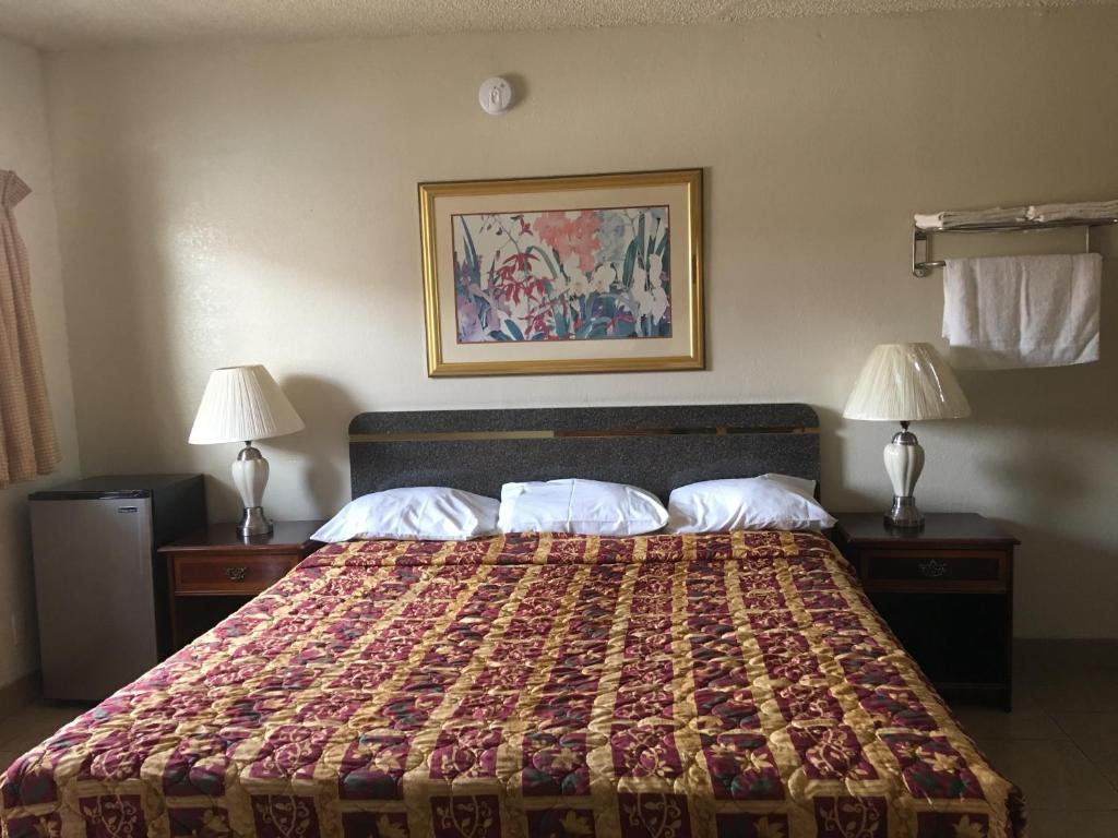 a bed in a hotel room with two lamps at Sand Piper Motel - Los Angeles in Los Angeles