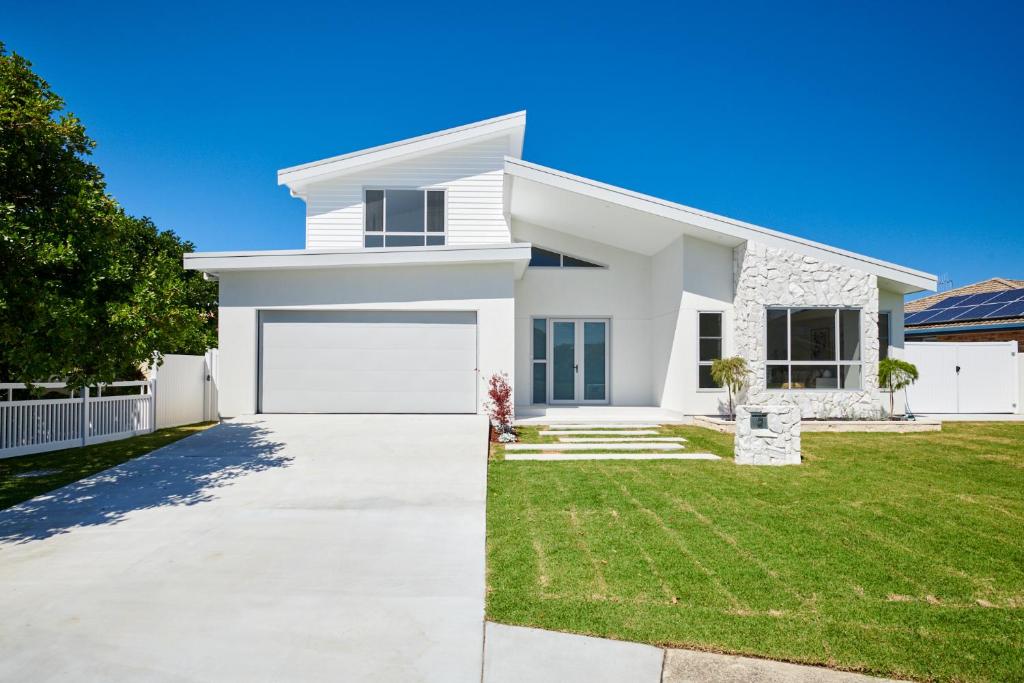 a white house with a garage at 2 Ulmarra in Manning Point