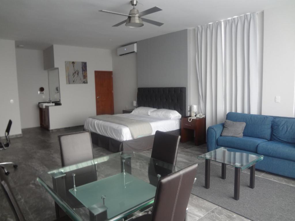 uma sala de estar com uma cama e um sofá azul em Hotel Civic Express em Poza Rica de Hidalgo