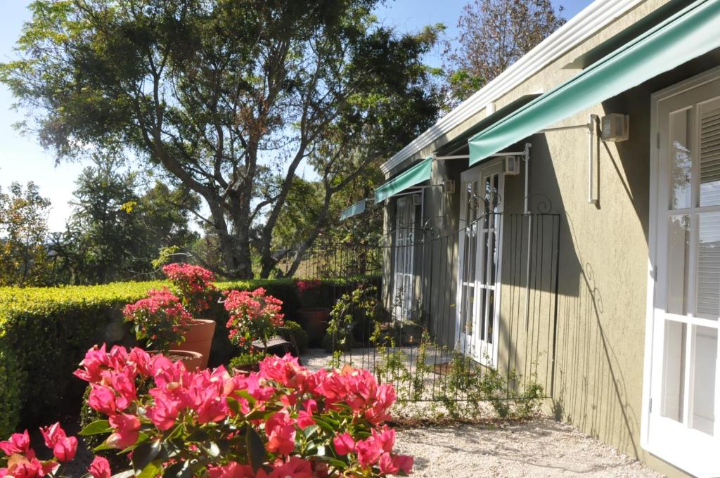 坎普斯杜若爾當的住宿－Passagem da Neblina - Bed & Breakfast，前院有粉红色花的房屋