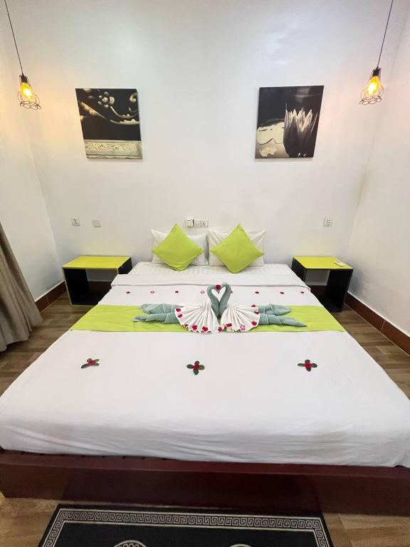 a bedroom with two beds with green and white sheets at Grand Apsara Residence in Siem Reap