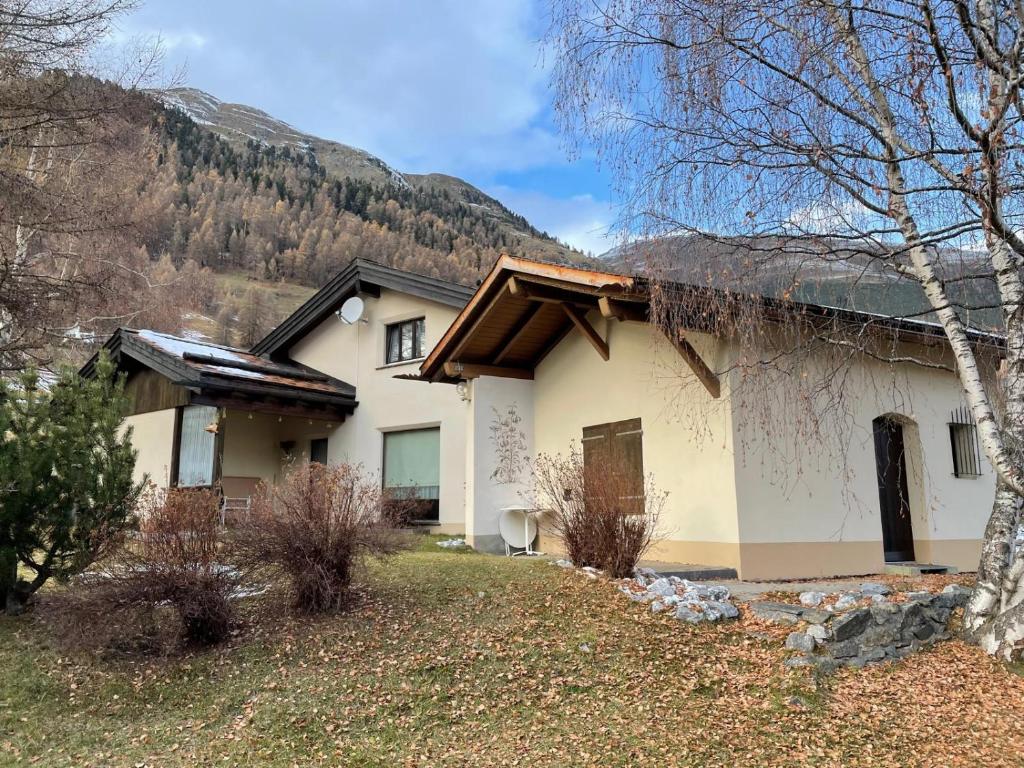 a house with a mountain in the background at Cottage Grundschera Engadin in Brail