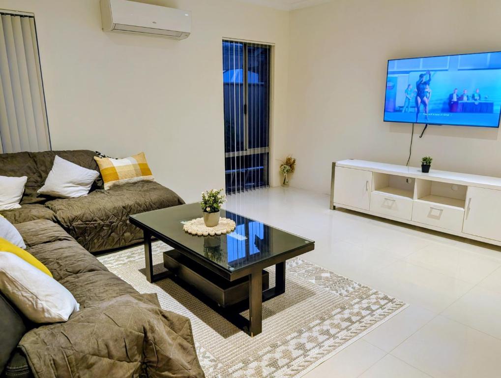 a living room with a couch and a coffee table at Grand stay in Perth
