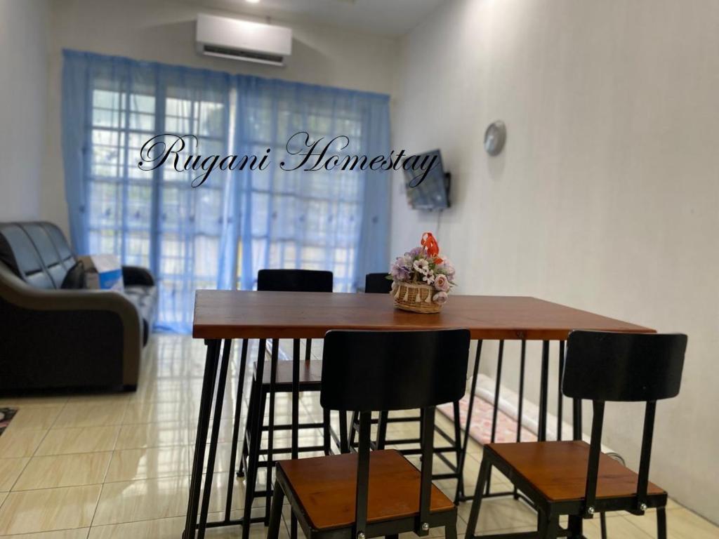a dining room table and chairs in a living room at Rugani Homestay in Papar