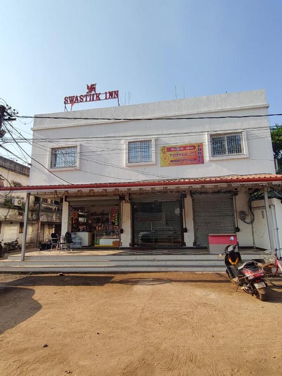 a building with a motorcycle parked in front of it at Swastiik Inn in Belpahār