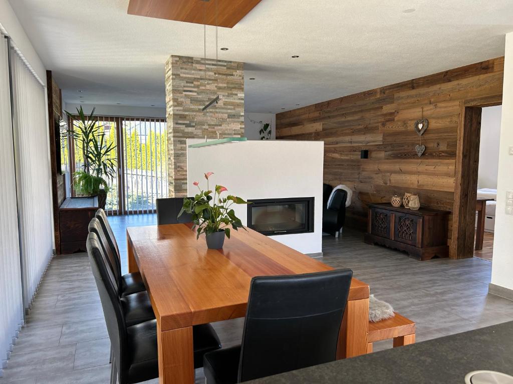 a dining room with a wooden table and a fireplace at Haus Dahuam in Sautens