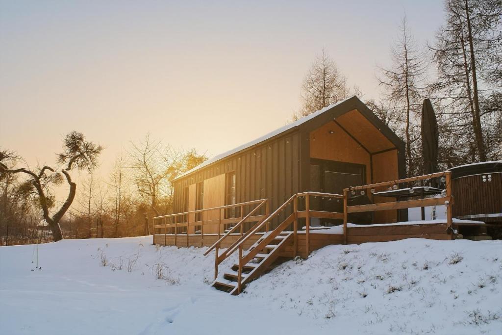a building with snow in front of it at Domek nad Drawskim in Stare Drawsko