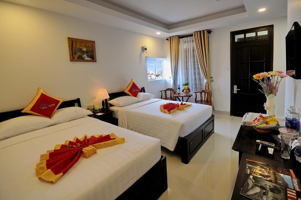 um quarto de hotel com duas camas com flores em Full House Hotel em Nha Trang