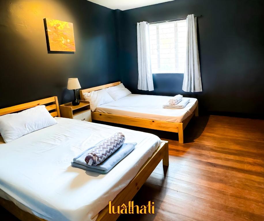two beds in a room with blue walls at Lualhati Homestay in Baguio