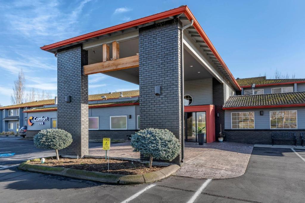 a building with two trees in a parking lot at Comfort Inn Columbia Gorge in The Dalles