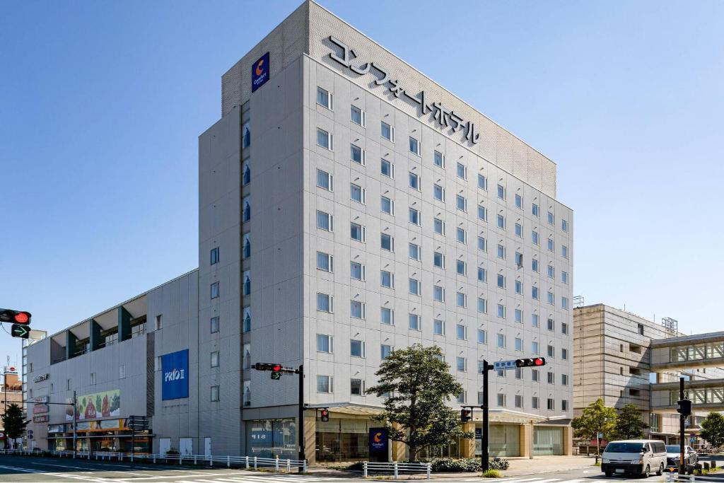 a white building with a sign on the side of it at Comfort Hotel Toyokawa in Toyokawa