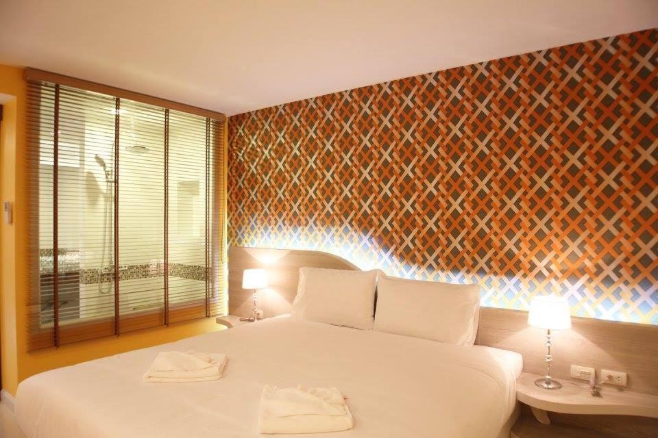 a bedroom with a large white bed and a window at Trebel Pattaya in Pattaya