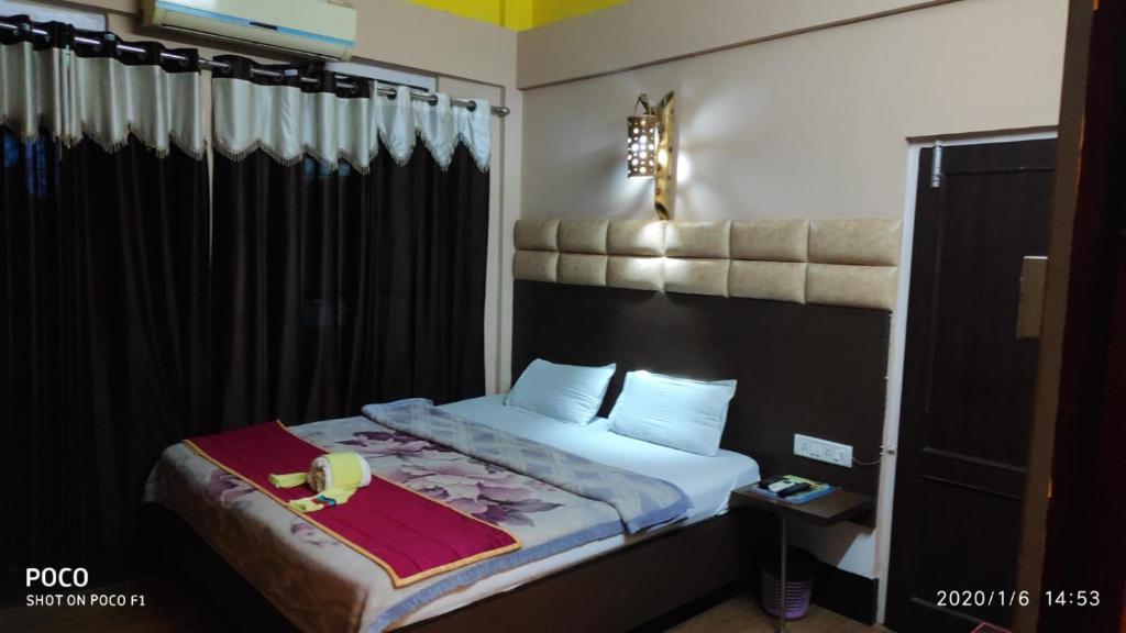 a bedroom with a bed with a black headboard at Executive Guest House in Guwahati