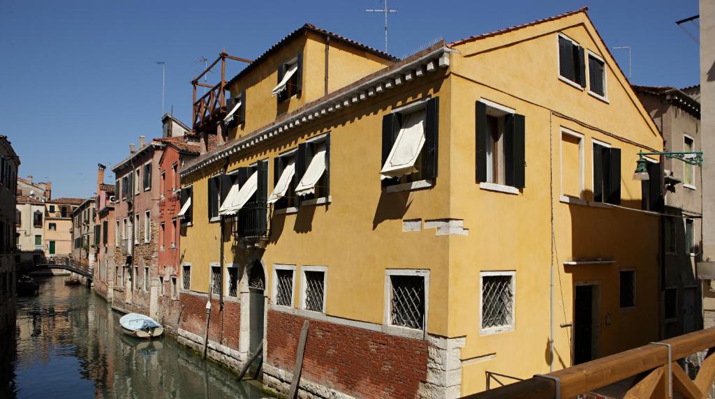 un edificio junto a un canal con un barco dentro en B&B Al Palazzetto, en Venecia