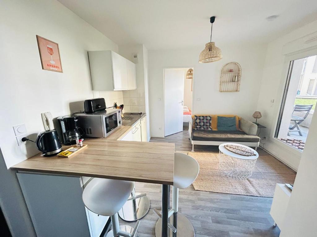 a kitchen and living room with a table and chairs at Appartement proche université in Caen