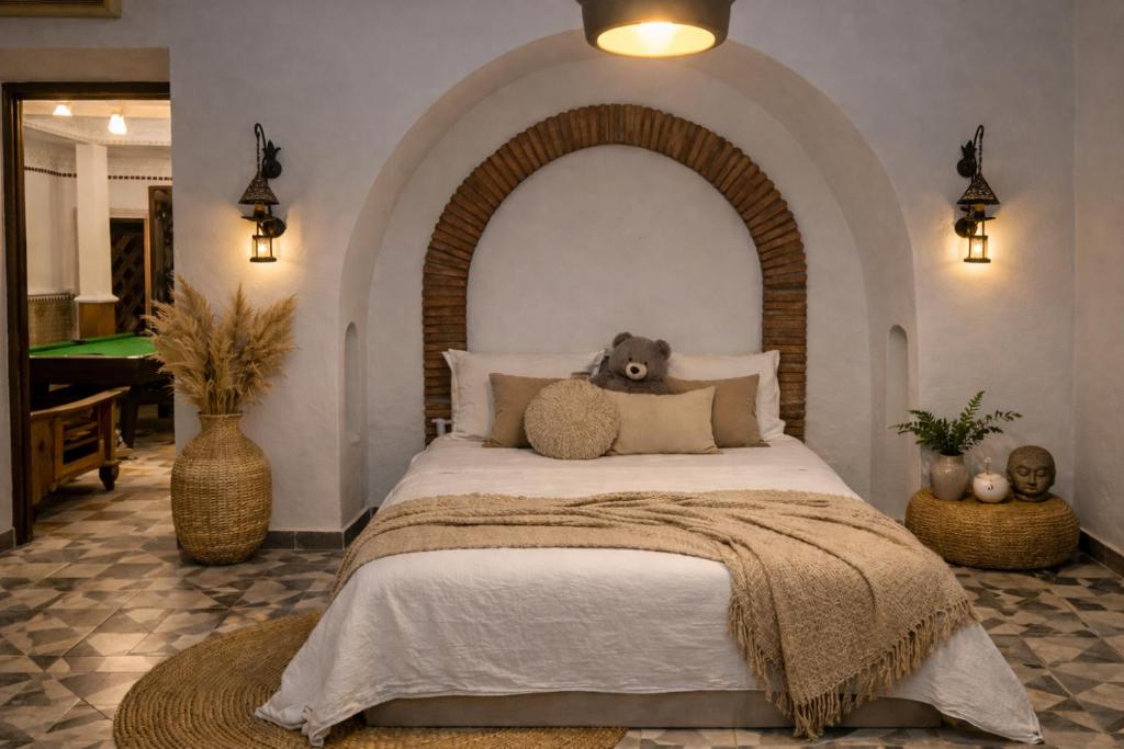 a bedroom with a bed with a teddy bear on it at Beau Riad de 3 chambres avec piscine à la rte d'Ourika in El Jemʼa Ghemat