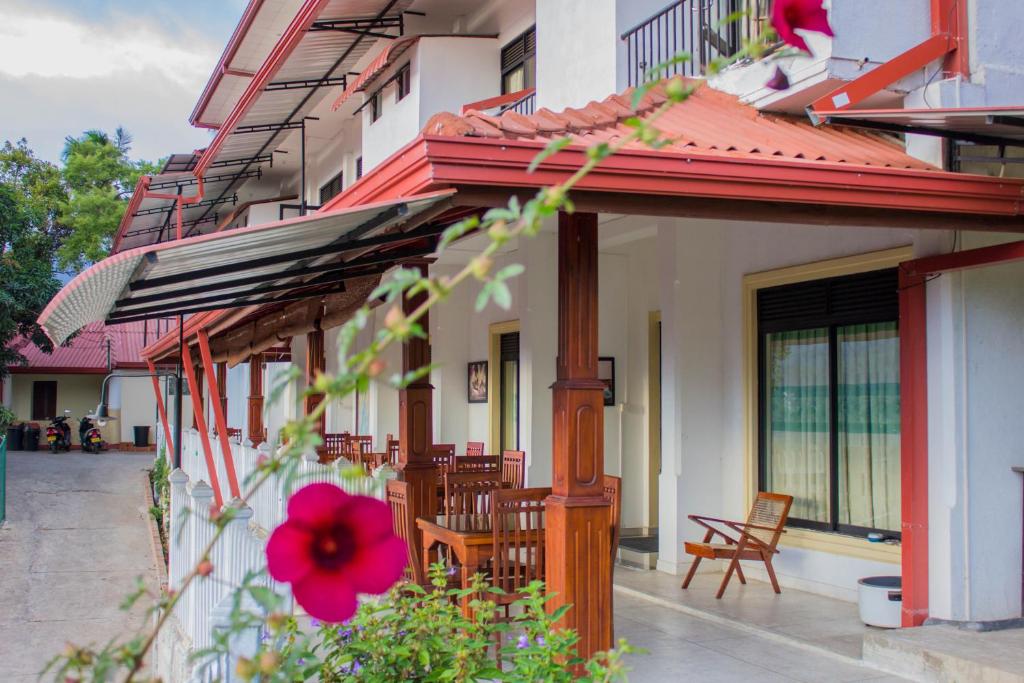 a building with chairs and flowers on a patio at Satyodaya Educational Training Centre in Kandy