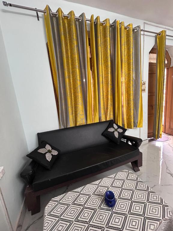 a black bench in a room with gold curtains at Shiva in Hāpur