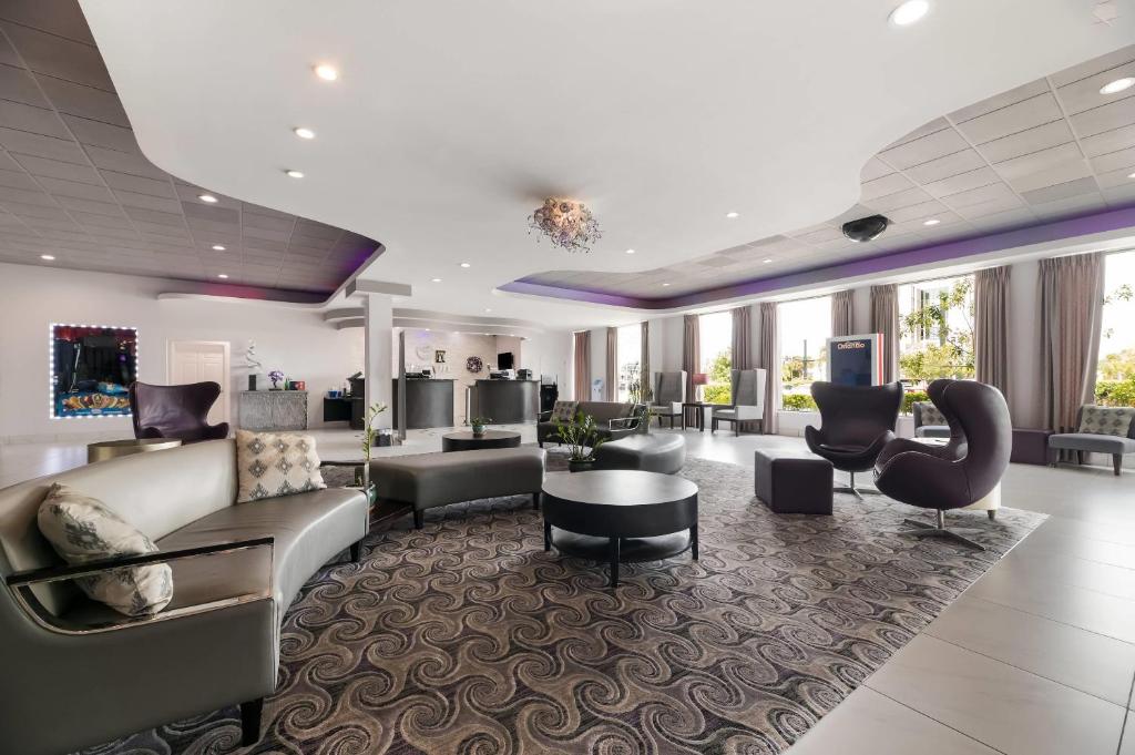 a lobby with a couch and chairs and a table at Clarion Inn & Suites Across From Universal Orlando Resort in Orlando