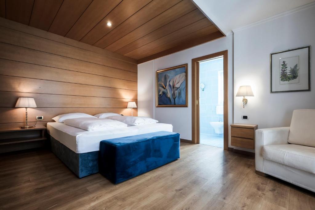 a bedroom with a large bed and a couch at Residence Villa Stella in Ortisei