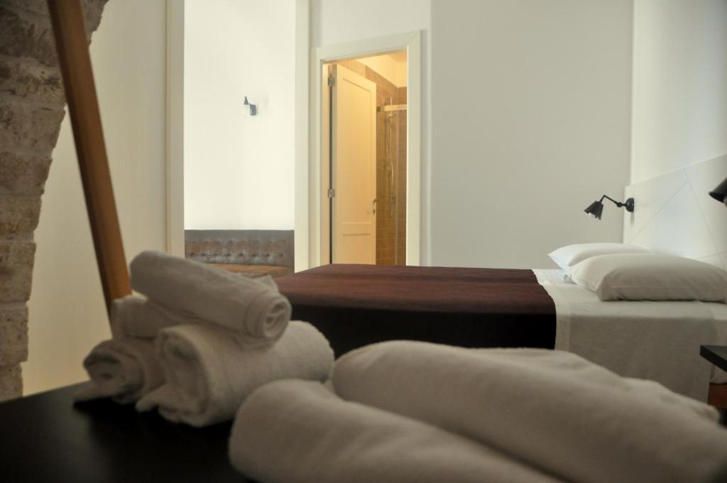 プティニャーノにあるPorta Barsentoのベッド2台、タオル、テーブルが備わる客室です。