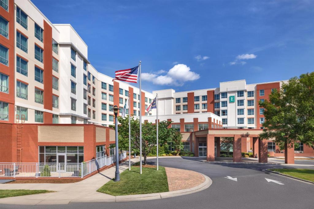 an exterior view of a building with an american flag at Embassy Suites Charlotte/Ayrsley in Charlotte