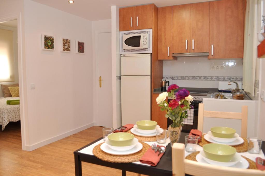 una cocina con una mesa con platos verdes. en bcn4days Apartments, en Hospitalet de Llobregat