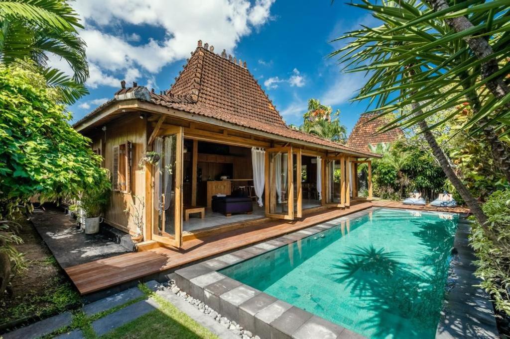 a villa with a swimming pool and a house at Villa Lucky in Canggu