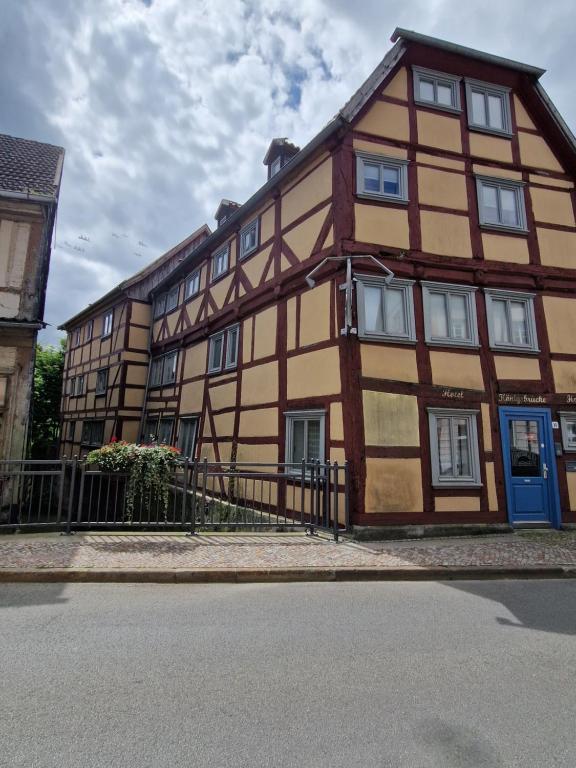 a large wooden building with a blue door at Hotel Beere in Salzwedel