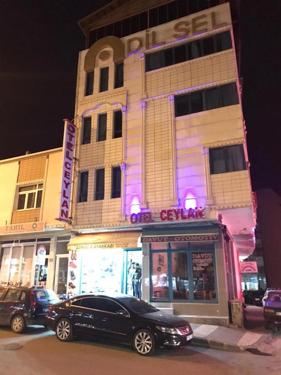 a black car parked in front of a building at Ceylan otel in Suşehri