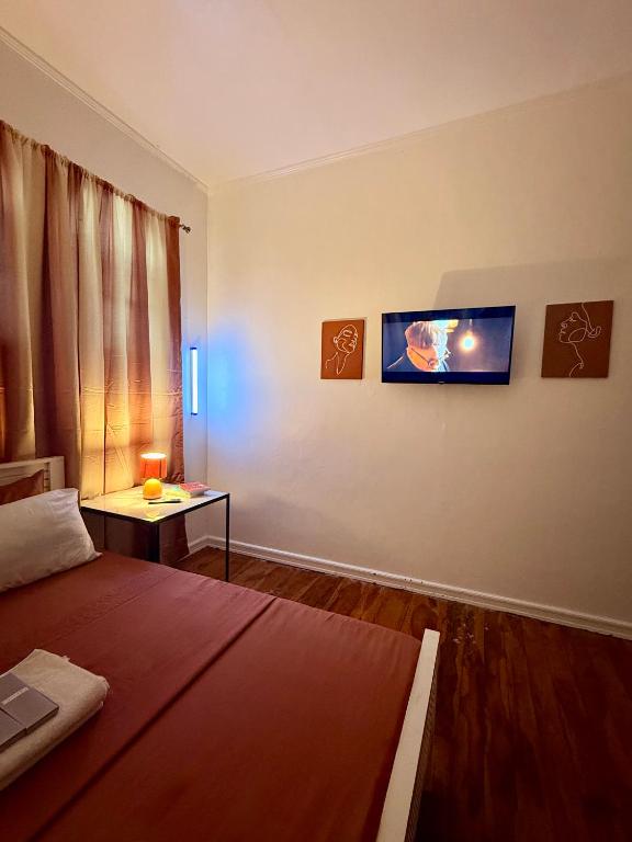 a bedroom with a bed and a table and a window at Haraya Beach House in Roxas City
