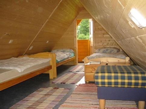 Habitación con 2 camas en una cabaña de madera en Ferienhaus Beme, en Spielberg