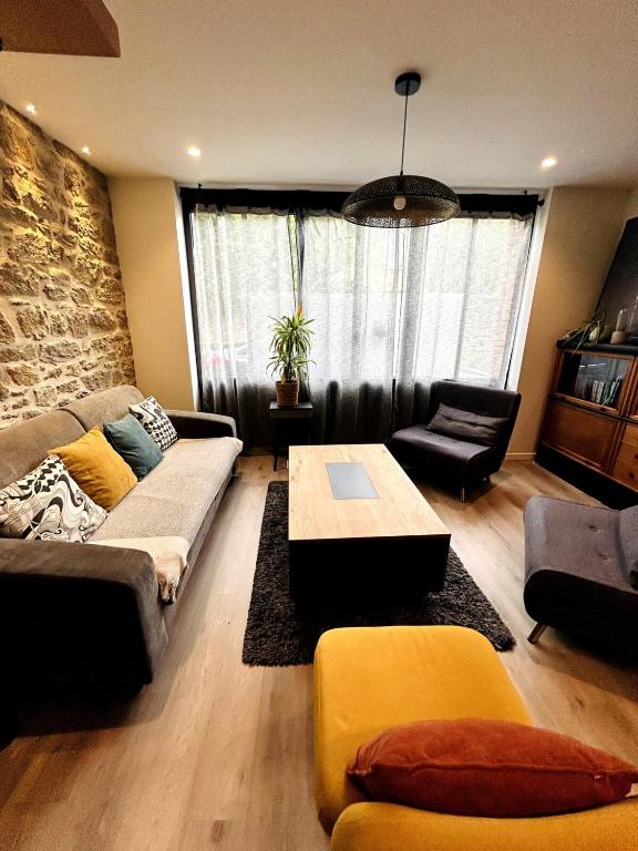 a living room with a couch and a table at Atelier Cancalais - Hypercentre, maison de ville in Cancale
