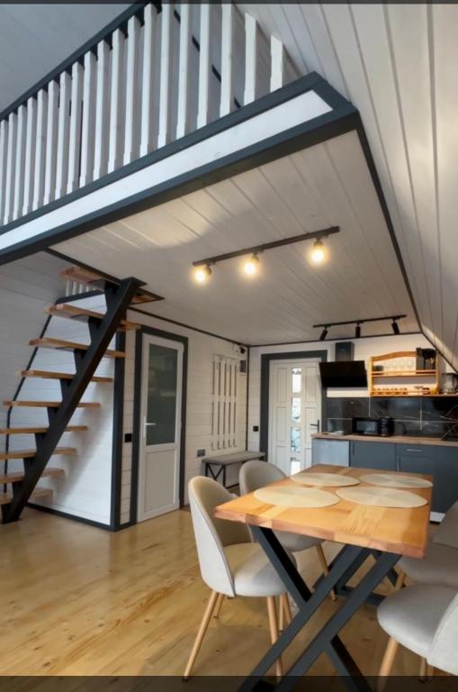 a dining room with a table and a staircase at Тиша in Verkhovyna