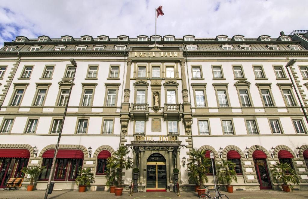 a large white building with a flag on top at Hotel Halm Konstanz in Konstanz