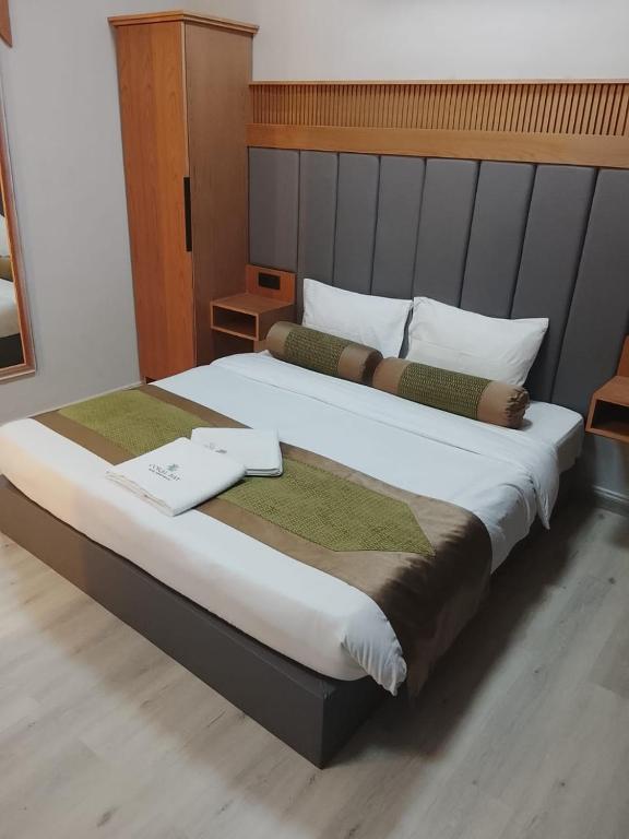a bedroom with a large bed in a room at Coral Bay Suite Hotel in Khor Fakkan
