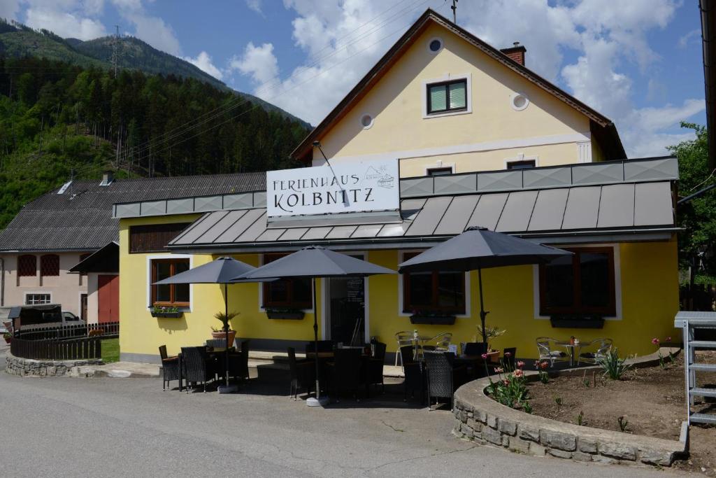 a restaurant with tables and umbrellas in front of a building at Ferienhaus Kolbnitz in Unterkolbnitz