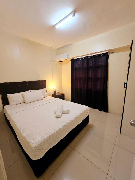 a bedroom with a large white bed with a window at Aurora Mirage Apartments in Nadi