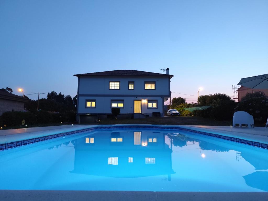 a house with a swimming pool in front of a house at Forxan in Sanxenxo