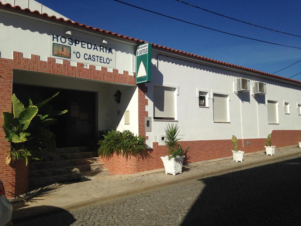 a white building with a sign that reads hos peruvian to oeston at Hospedaria O Castelo in Portel