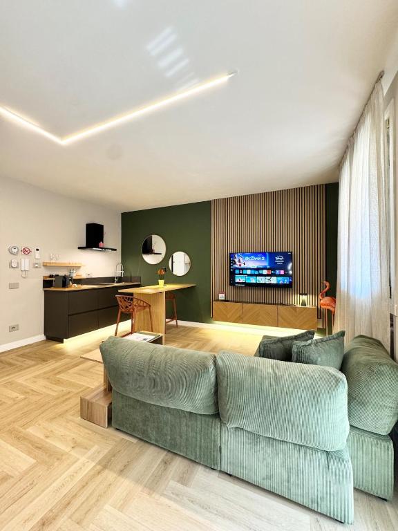a living room with a couch and a tv at Valcamonica Apartments - Lake in Boario Terme