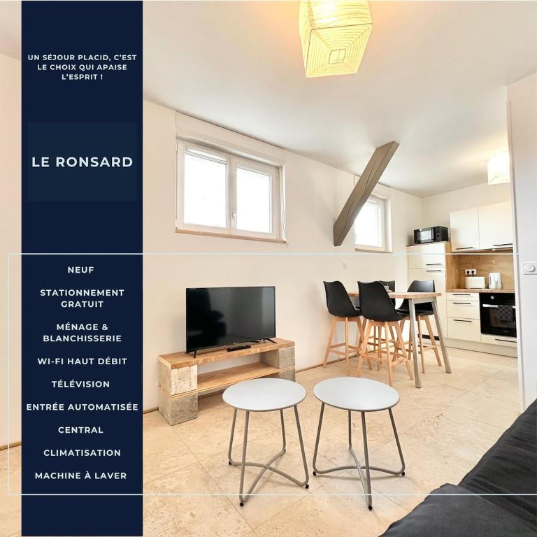 a living room with a tv and a table and chairs at Le Ronsard - Élégance - Central in Mont-de-Marsan