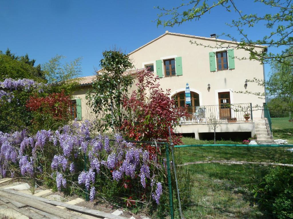 une maison avec des fleurs violettes devant elle dans l'établissement Le Val Léron, à Valaurie