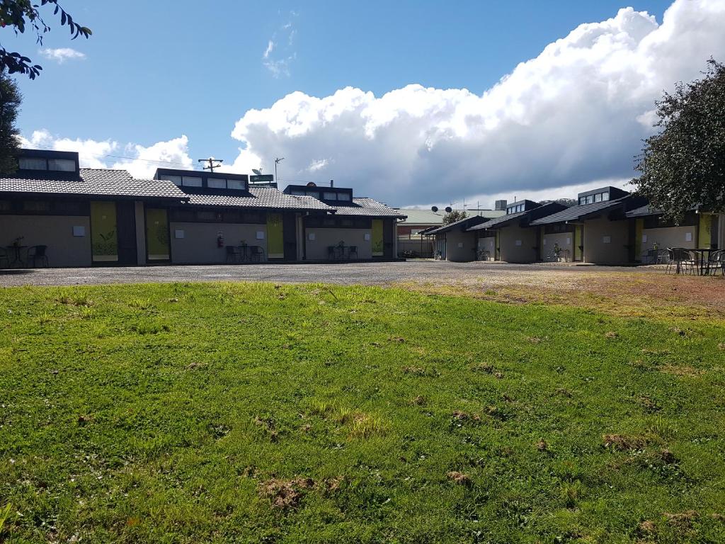 a row of buildings with a grass field in front at The Apple Inn in Batlow