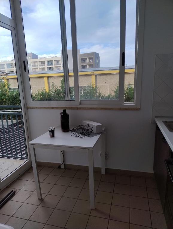 a white table in a room with two windows at Petit Appartament in Policoro