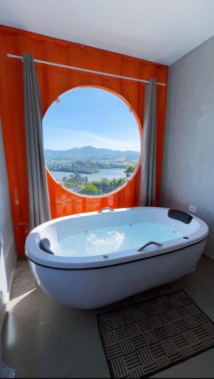 a bath tub in a bathroom with an open window at Amsterdam Lofts Deluxe in Poços de Caldas