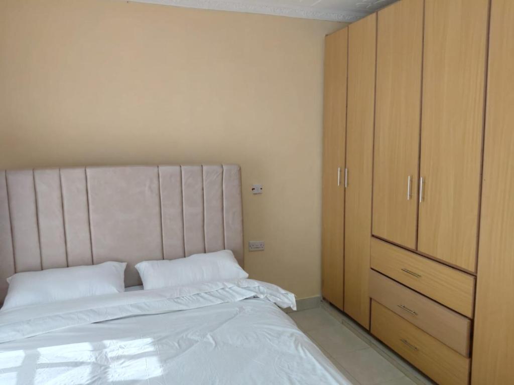 a bedroom with a bed and a wooden cabinet at Kelhanil Homes in Narok