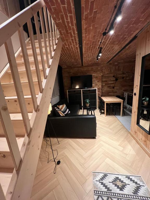 a living room with a staircase and a couch at Apartament M6 in Leśna