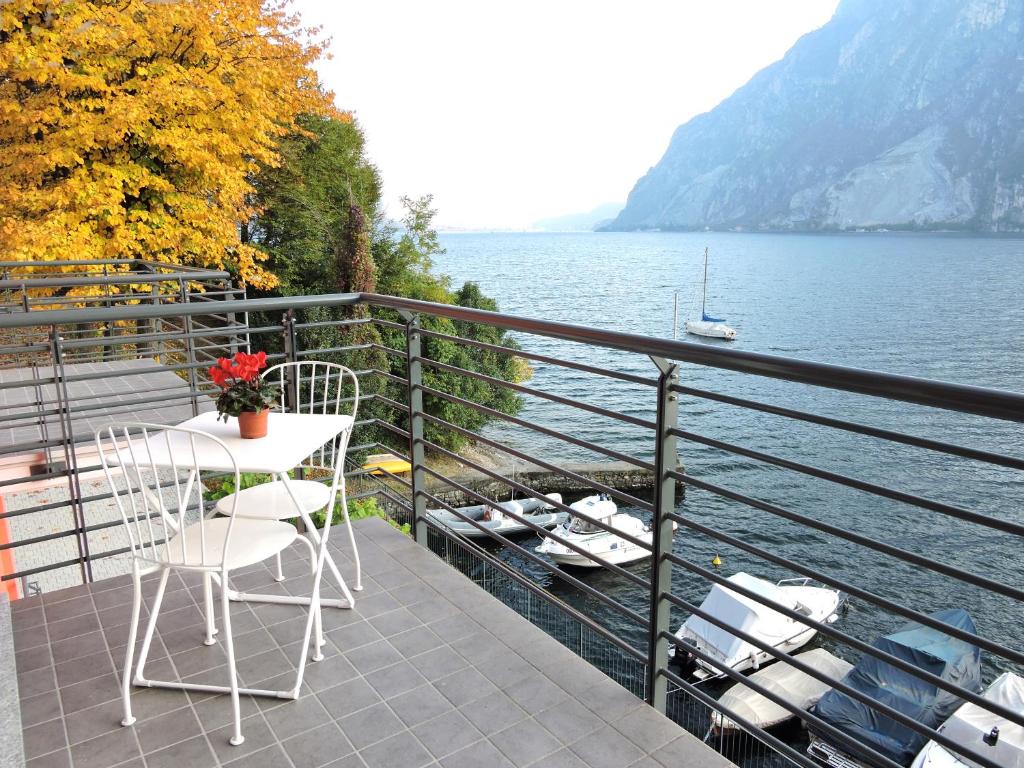 a table and chairs on a balcony overlooking a lake at a...fior di lago in Abbadia Lariana